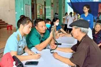 Các y, bác sĩ Trung đoàn 916 (Sư đoàn Không quân 371) đo huyết áp, tư vấn sức khỏe cho đối tượng chính sách đến khám bệnh.