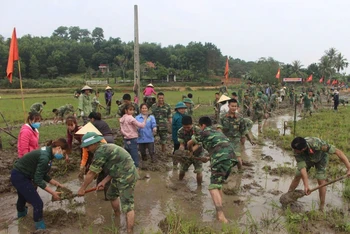 Cán bộ, chiến sĩ lực lượng vũ trang Quân khu 4 giúp nhân dân nạo vét kênh mương nội đồng. 