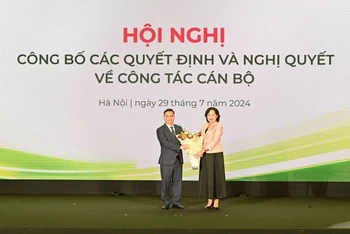 Thống đốc Ngân hàng Nhà nước Việt Nam Nguyễn Thị Hồng (bên phải) tặng hoa chúc mừng tân Chủ tịch Hội đồng Quản trị Vietcombank Nguyễn Thanh Tùng.