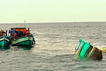 Bộ đội Biên phòng Cà Mau hỗ trợ trục vớt tàu cá ngư dân gặp nạn trên biển. (Ảnh: Lê Khoa) 
