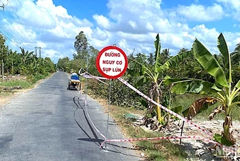 Giăng dây, cắm biển cảnh báo đường sụt lún nguy hiểm ở vùng ngọt huyện Trần Văn Thời, tỉnh Cà Mau. 