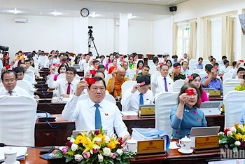 Các đại biểu Hội đồng nhân dân tỉnh Cà Mau biểu quyết thông qua 16 nghị quyết tại kỳ họp.