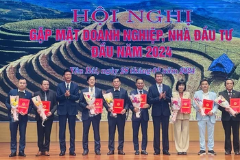 Chủ tịch Ủy ban nhân dân tỉnh Trần Huy Tuấn trao chứng nhận đầu tư cho các doanh nghiệp mới. (Ảnh THANH SƠN)