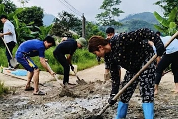 Nông dân huyện Lục Yên tham gia khắc phục giao thông nông thôn. (Ảnh: THANH SƠN)