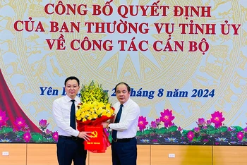 Đồng chí Tạ Văn Long, Phó Bí thư Thường trực Tỉnh ủy tặng hoa Chánh Văn phòng Tỉnh ủy An Hoàng Linh. (Ảnh: THANH SƠN)