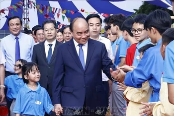 Chủ tịch nước Nguyễn Xuân Phúc với học sinh Trường Tiểu học, Trung học cơ sở và Trung học phổ thông Hy Vọng. (Ảnh TTXVN)