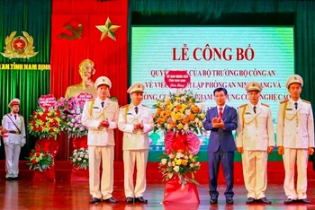 Đồng chí Phạm Đình Nghị, Chủ tịch UBND tỉnh Nam Định tặng hoa chúc mừng đại diện Phòng An ninh mạng và phòng, chống tội phạm sử dụng công nghệ cao thuộc Công an tỉnh.