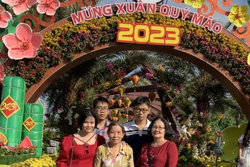 Gia đình chụp ảnh lưu niệm tại vườn hoa Xuân sáng mùng 2 Tết.