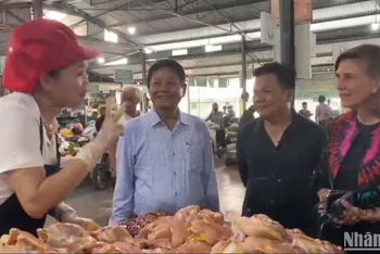 Tiểu thương phấn khởi chia sẻ với các đại biểu tại chợ.