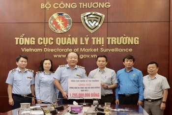 Tổng cục trưởng Quản lý thị trường Trần Hữu Linh trao biển tượng trưng số tiền gần 1,3 tỷ đồng cho Công đoàn Bộ Công thương để kịp thời ủng hộ đến người dân vùng lũ. 