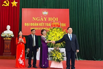 Đồng chí Nguyễn Trọng Nghĩa tặng hoa, chúc mừng Ngày hội Đại đoàn kết toàn dân tộc tại thôn Cổ Miếu.