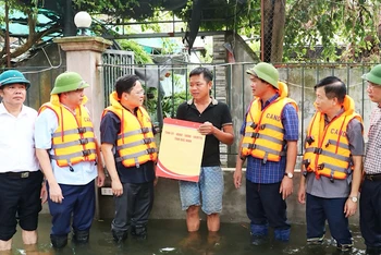 Đồng chí Bí thư Tỉnh ủy Bắc Ninh Nguyễn Anh Tuấn (thứ 3 từ trái sang) cùng các đồng chí lãnh đạo tỉnh tặng quà người dân đang bị lũ cô lập tại xã Hòa Tiến, huyện Yên Phong.