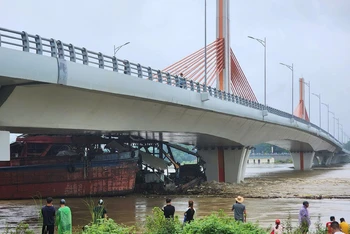 Các tàu mắc kẹt dưới gầm cầu và có nguy cơ bị chìm do nước ngày càng dâng cao.