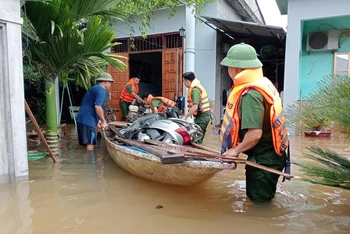 Lực lượng công an giúp người dân di dời tài sản ra khỏi khu vực ngập lụt.