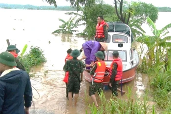 Các đơn vị vũ trang di dời người dân khu vực bãi bồi Phú Động vào nơi an toàn.