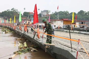 Nước từ thượng nguồn đổ về kéo theo nhiều cây cối khiến cầu phao phải đóng để bảo đảm an toàn.