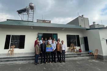 Hội viên Câu lạc bộ 65 trao tiền hỗ trợ xây nhà tình nghĩa cho ông Đinh Văn Tâm tại ngôi nhà mới.
