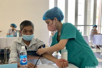 Các cán bộ y, bác sĩ thăm khám sức khỏe cho người dân trên địa bàn huyện Mê Linh.