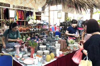 Khách tham quan mua sắm các sản phẩm hàng lưu niệm của Hà Nội.