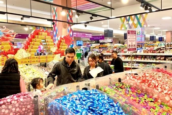 Người tiêu dùng mua bánh kẹo Tết tại siêu thị Aeon Long Biên.