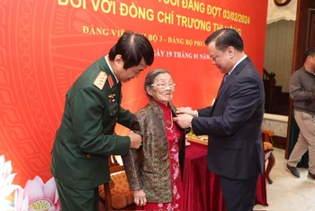 Bí thư Thành ủy Hà Nội Đinh Tiến Dũng trao Huy hiệu cho đảng viên lão thành.