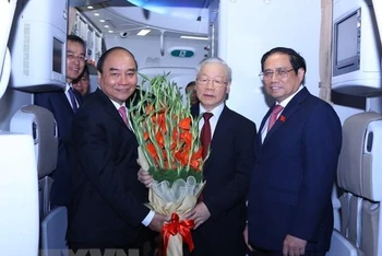 Chủ tịch nước Nguyễn Xuân Phúc, Thủ tướng Chính phủ Phạm Minh Chính đón và tặng hoa Tổng Bí thư Nguyễn Phú Trọng. (Ảnh: TTXVN) 