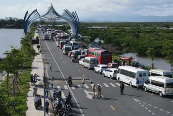 Ô tô chở khách du lịch tham quan đảo Cát Bà xếp hai hàng chạy dài hơn 1 km trên đường tỉnh 356 tại đầu bến Cái Viềng, chờ đến lượt xuống phà trở về đất liền. Ảnh : Báo Thanh Niên 