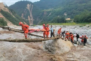 Lực lượng cứu hộ làm cầu tạm để di chuyển người bị thương đi cấp cứu. (Ảnh: Tân Hoa Xã)