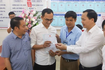 Phó Tổng Giám đốc Chu Mạnh Sinh trao thẻ bảo hiểm y tế của bé gái Đinh Bảo N. cho anh Đinh Tiến Hoàng.