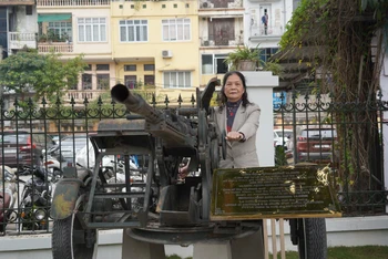 Bà Phạm Thị Viễn bên khẩu súng cao xạ tại Bảo tàng Chiến thắng B52.