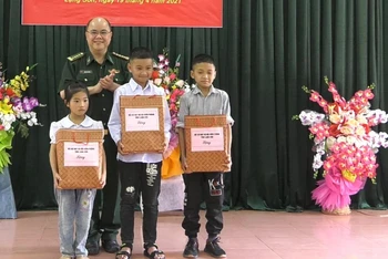 Cán bộ chiến sĩ đồn biên Phòng Chi Lăng, Lộc Bình (Lạng Sơn) tặng sách vở cho các em học sinh là con nuôi đồn biên phòng.