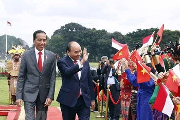 Chủ tịch nước Nguyễn Xuân Phúc và Tổng thống nước Cộng hòa Indonesia Joko Widodo tại lễ đón. (Ảnh: TTXVN)