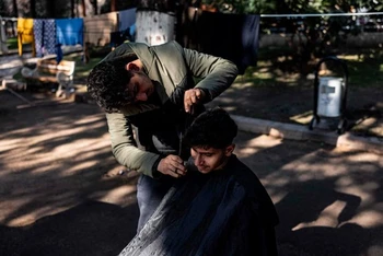 Mohammed al-Hamo cắt tóc tại khu tạm trú. (Nguồn: AFPPIX)