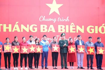 Đồng chí Nguyễn Ngọc Lương (thứ 7 từ trái sang) trao cờ Tổ quốc tặng đại diện người dân khu vực biên giới tại tỉnh Lạng Sơn.