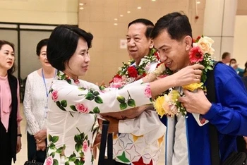 Phó Tổng cục trưởng Thể dục-Thể thao Lê Thị Hoàng Yến tặng hoa cho đại diện Đoàn rước đuốc Campuchia tại sân bay Nội Bài. (Ảnh: Tổng cục Thể dục-Thể thao).