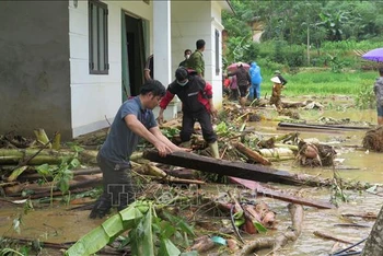 Người dân địa phương nỗ lực tìm người thân bị nạn sau lũ dữ. Ảnh: Hồng Ninh/TTXVN