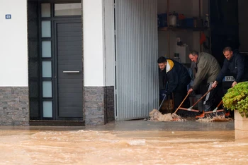 Người dân ngăn chặn nước vào nhà. Ảnh: Reuters.