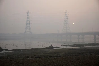 Một người đàn ông đi bộ trên bờ sông Yamuna vào một buổi sáng sương mù ở New Delhi, Ấn Độ. (Ảnh: Reuters)