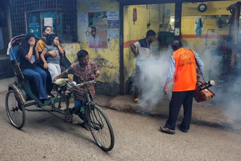 Một công nhân đang phun thuốc khử trùng để diệt muỗi tại Dhaka, Bangladesh. Ảnh: Reuters