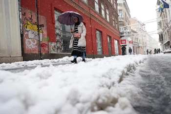 Một người phụ nữ đi trên phố trong cơn bão tuyết ở Sarajevo, Bosnia và Herzegovina. Ảnh: Reuters