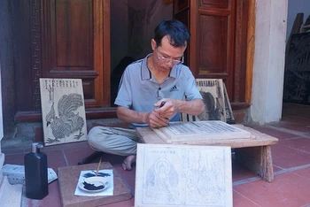 Anh Nguyễn Văn Thạo đang khắc mộc bản.