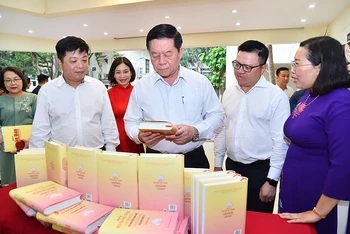 Đồng chí Nguyễn Trọng Nghĩa, Bí thư Trung ương Đảng, Trưởng Ban Tuyên giáo Trung ương cùng các đại biểu tham quan trưng bày cuốn sách. (Ảnh THỦY NGUYÊN)