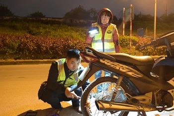 Thành viên Đội Cứu hộ Hà Nội vá xe giúp người đi đường trong đêm.