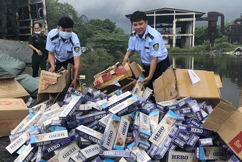 Lực lượng Quản lý thị trường tỉnh Kiên Giang tiêu hủy thuốc lá nhập lậu thu giữ được. (Ảnh HỒNG CHỨC)