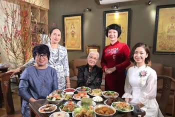 Nhà báo Vũ Thị Tuyết Nhung (thứ hai từ trái sang) cùng chuẩn bị mâm cỗ Tết của người Hà Nội với gia đình bà Lại Đoan Trang (phố Bà Triệu).