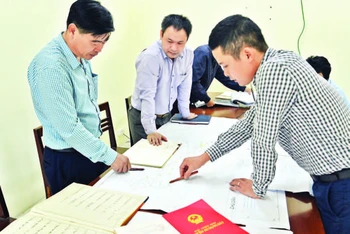 Lãnh đạo UBND xã Ninh Sở, huyện Thường Tín đối chiếu, rà soát diện tích thu hồi đất phục vụ giải phóng mặt bằng để thi công tuyến đường vành đai 4 trên địa bàn. (Ảnh: DUY LINH)