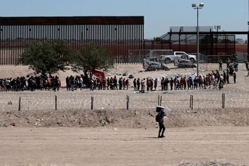 Người di cư xếp hàng tại khu vực biên giới Mỹ-Mexico.