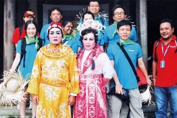 Vợ chồng ông Lê Phú Hải với các du khách tham quan Hội An. (Ảnh Hồ Hoa)