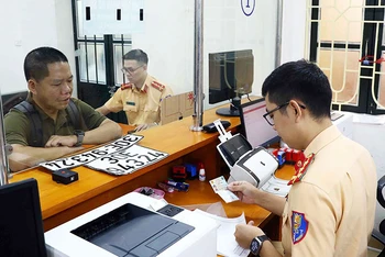 Người dân làm thủ tục thu hồi biển số xe tại cơ sở đăng ký số 1, Phòng Cảnh sát giao thông Công an thành phố Hà Nội. (Ảnh: PHẠM KIÊN)