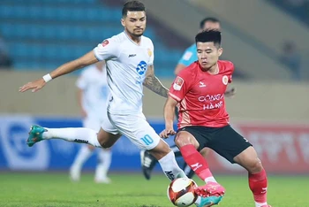 Nỗ lực đi bóng của cầu thủ Công an Hà Nội (áo đỏ) trước Thép Xanh Nam Định. 